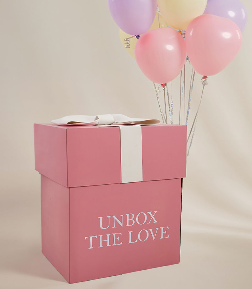 Pastel balloon surprise gift box with pink packaging and white ribbon for Valentine's Day