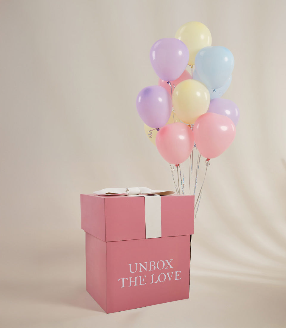 Pastel balloon surprise gift box with pink packaging and "Unbox the Love" message for Valentine's Day