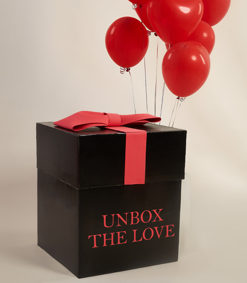 Red balloon surprise gift box with black packaging and silver ribbon for Valentine's Day