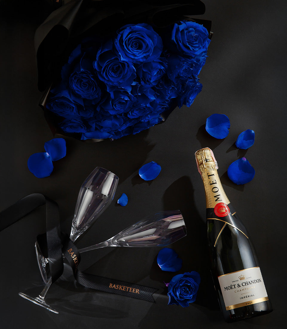 Luxury champagne gift set with blue roses, two flutes, and gold-foil bottle for Valentine's Day