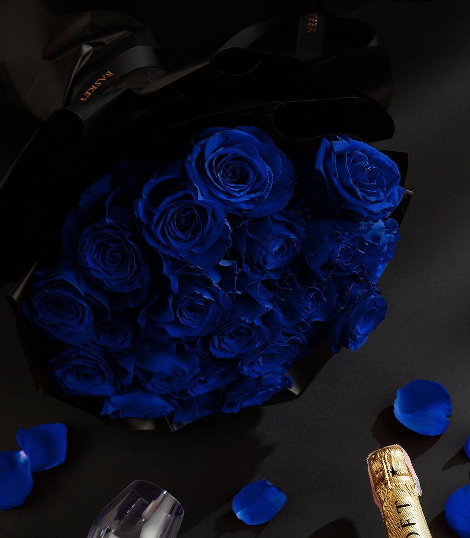 Luxury champagne gift set with blue roses, champagne flute, and heart chocolates for Valentine's Day