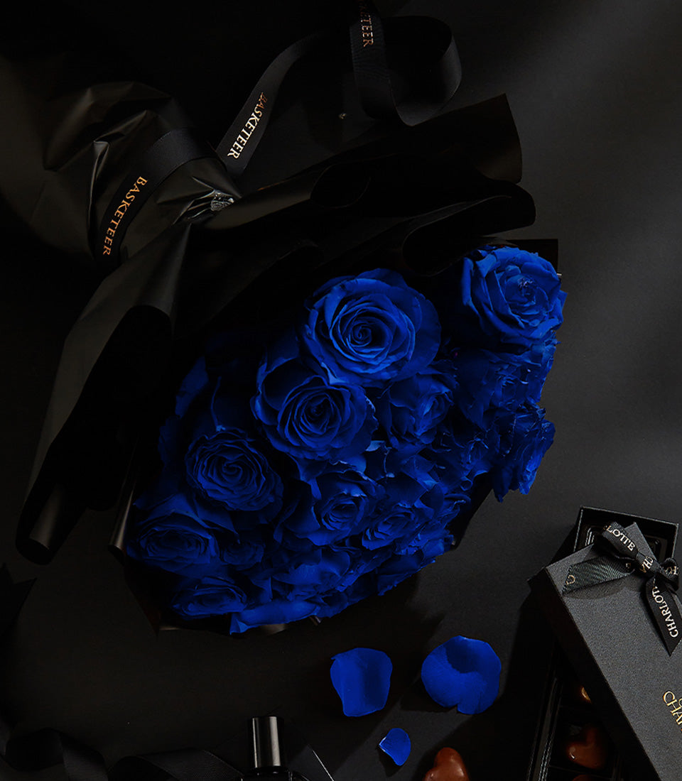 Luxury Valentine's gift set with blue roses, artisan chocolates, and premium fragrance in black matte packaging