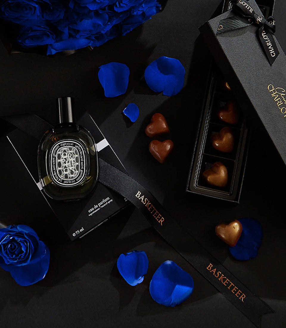 Luxury Valentine's gift set with eau de parfum, artisan heart chocolates, and blue roses for men