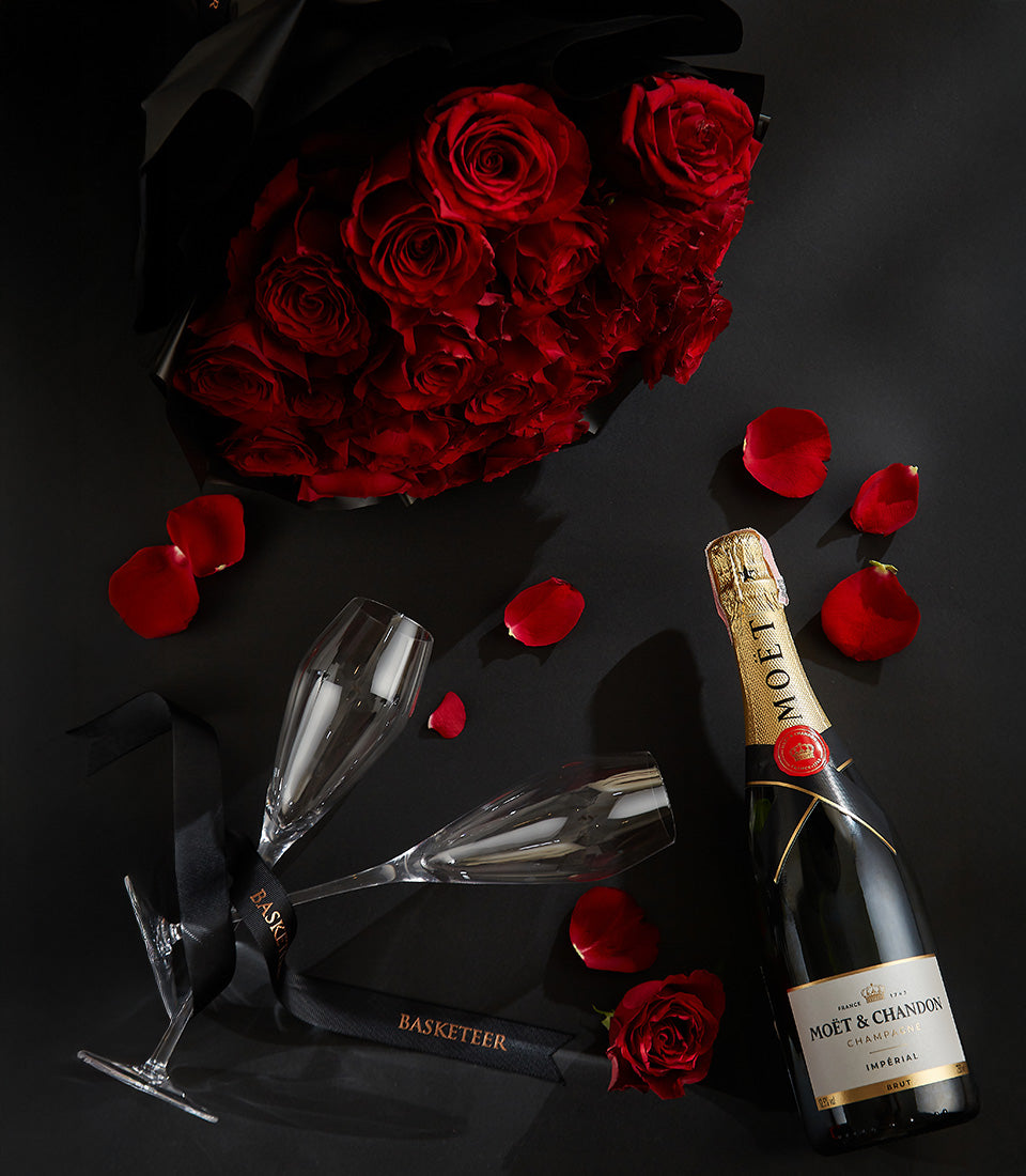Romantic champagne and red roses gift set with flutes and gold foil bottle for Valentine's Day