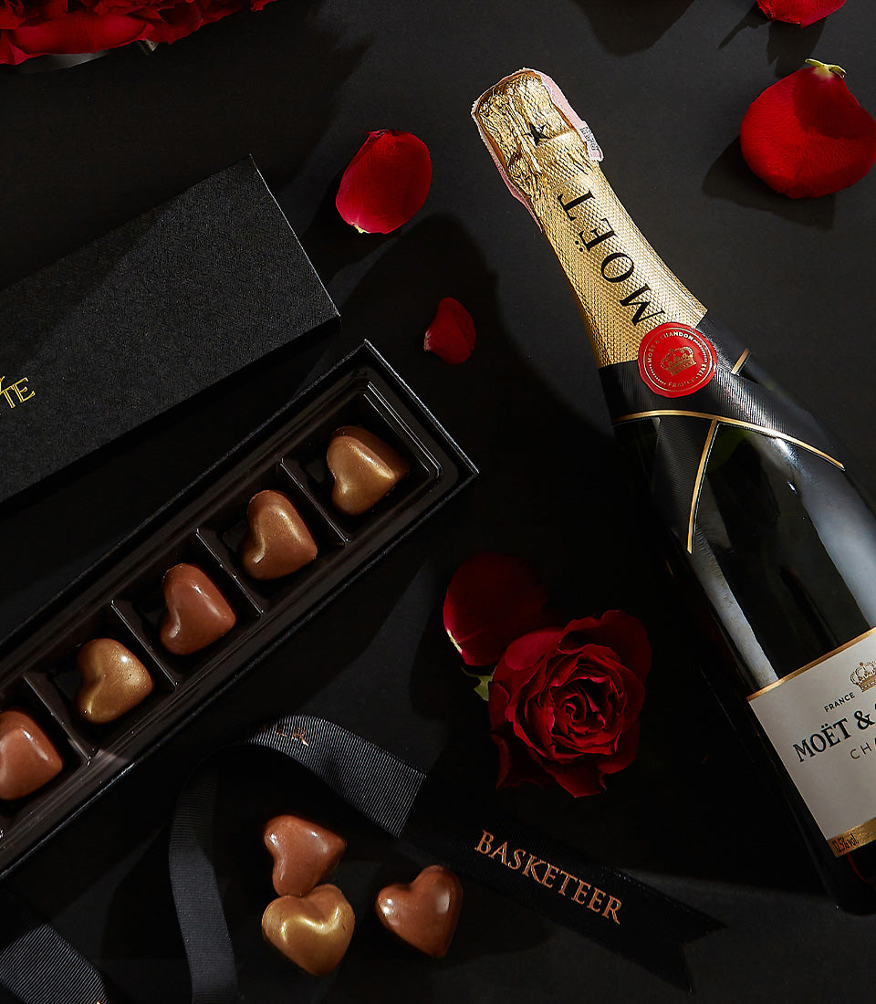 Luxury Valentine's champagne gift set with heart-shaped chocolates, red rose, and elegant black packaging