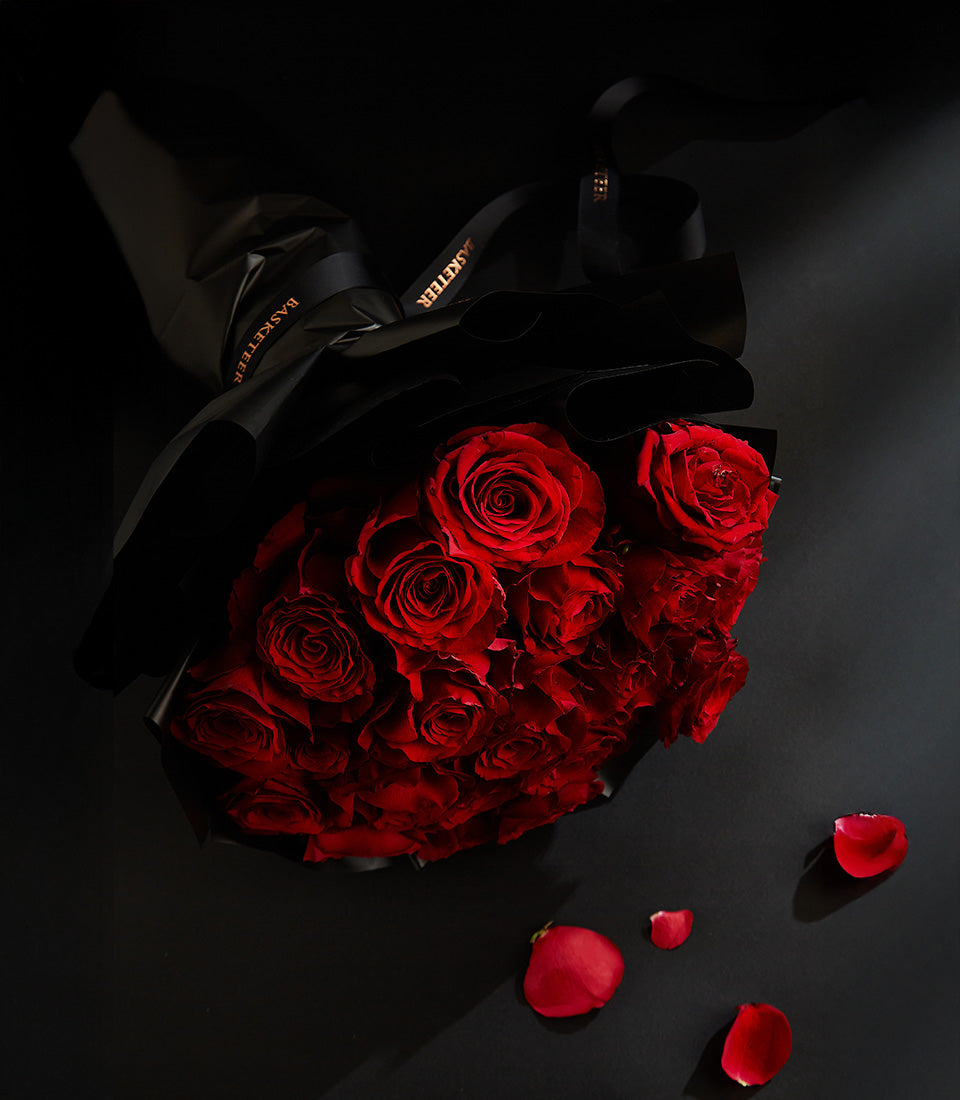 Luxury red rose bouquet with champagne, black wrapping and romantic presentation for Valentine's Day
