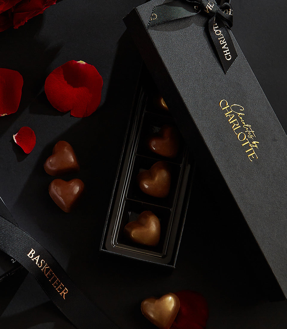 Red roses with heart-shaped chocolates in luxury black gift box, Valentine's Day romance gift set