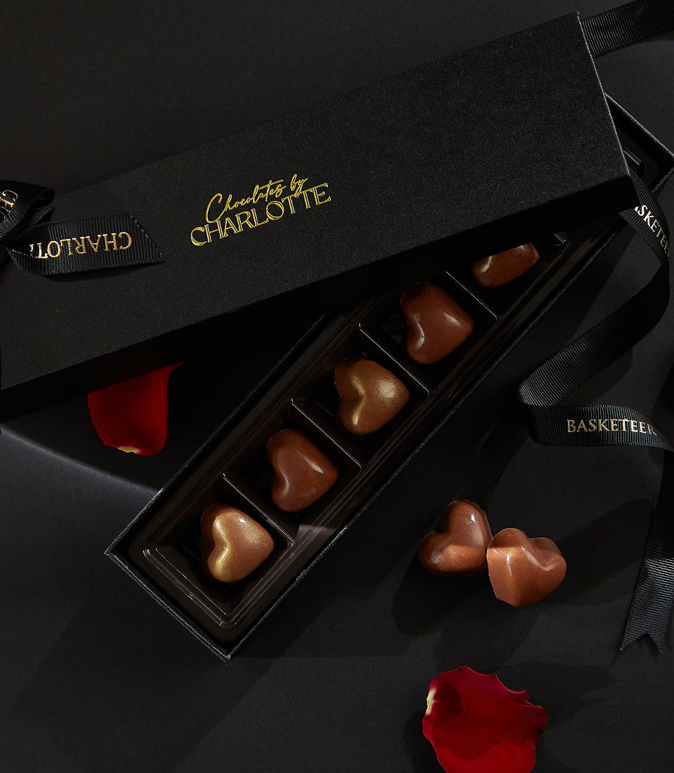 Heart-shaped artisan chocolates in a sleek Charlotte Bakery gift box, perfect for birthday cake delivery Bangkok. British bakery Thailand.