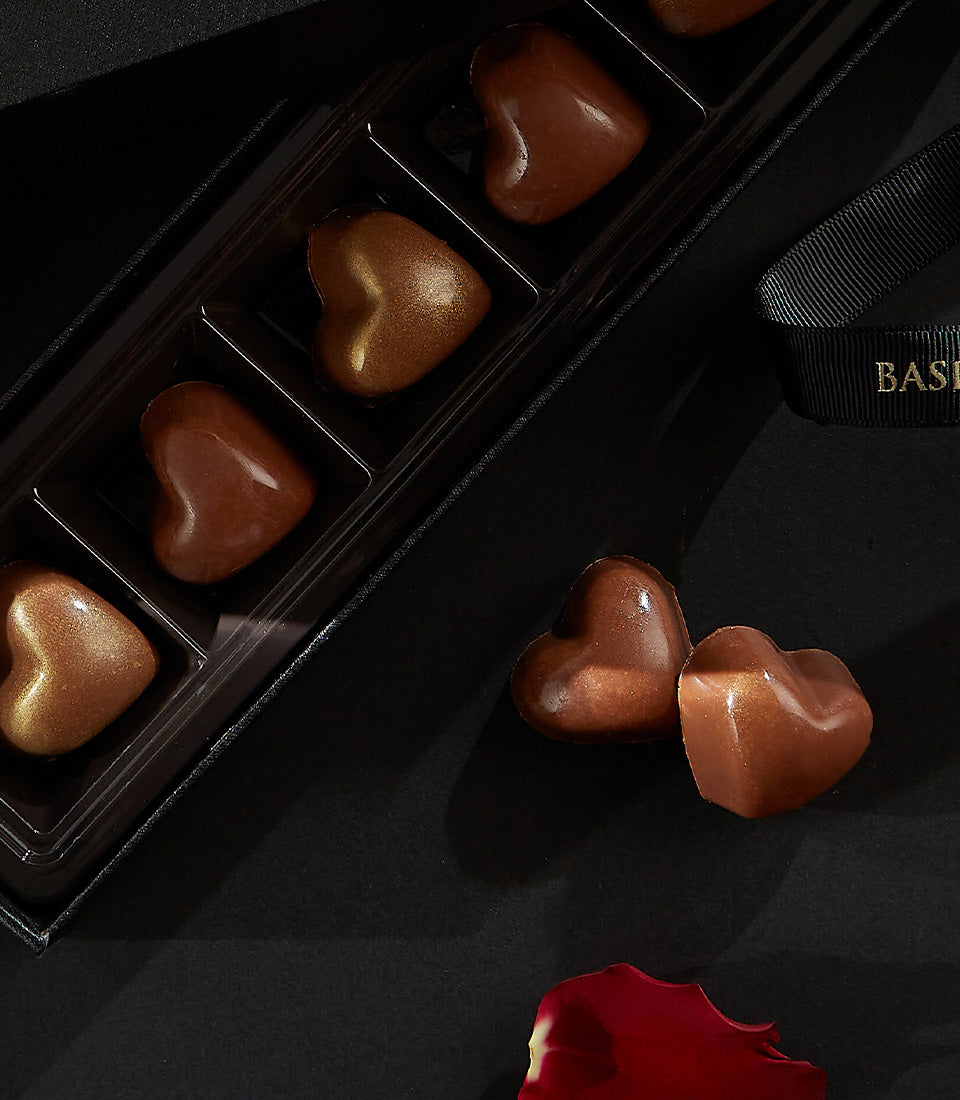Charlotte Bakery artisan chocolate bonbons: Heart-shaped chocolates, some in a sleek black box, perfect for birthday cake delivery Bangkok.