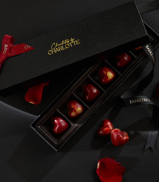 Heart-shaped cherry liquor truffles in luxury black box with gold accents, romantic Valentine's chocolate gift