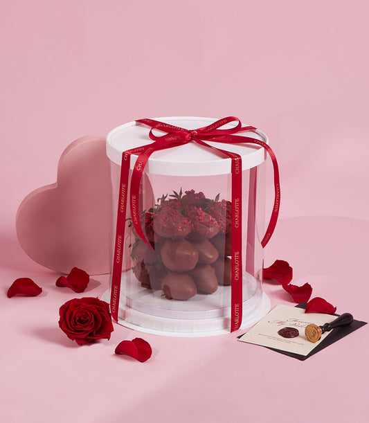 Luxury dark chocolate-covered strawberries with raspberry sprinkles in elegant gift box with red Charlotte ribbon,
