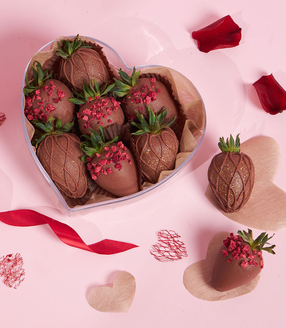 Charlotte Bakery dark chocolate-covered strawberries in a heart-shaped box, some drizzled with gold and others topped with raspberry. Perfect artisan cake order for Bangkok delivery.
