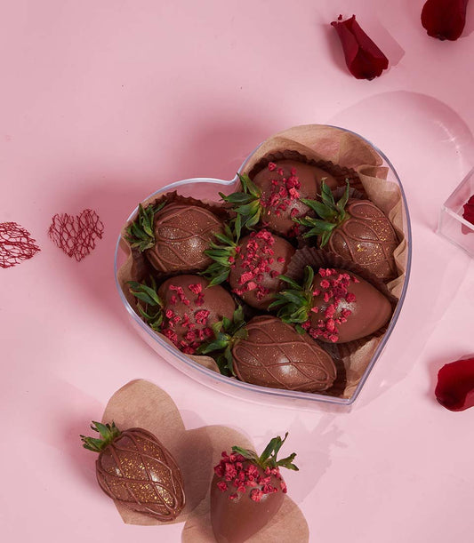 Romantic heart-shaped box with chocolate-covered strawberries and preserved rose petals for Valentine's Day