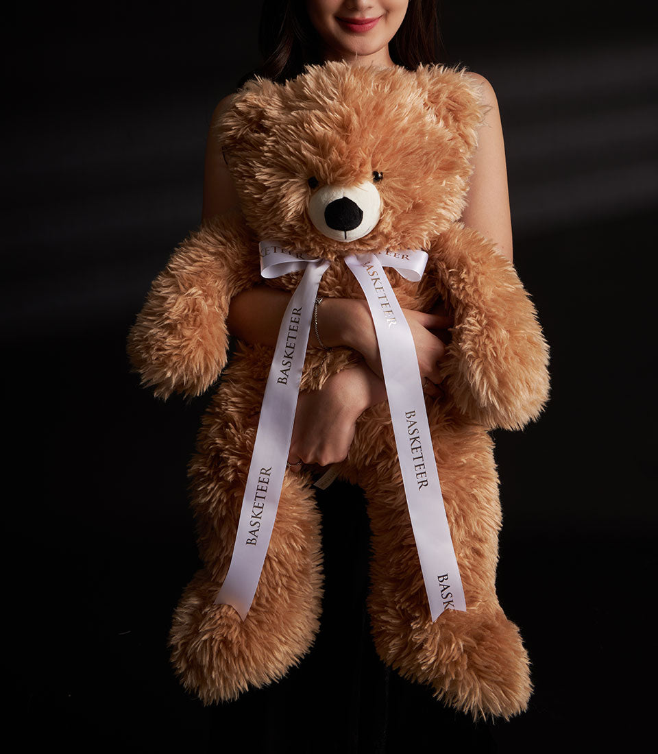 Large fluffy brown teddy bear with white ribbon bow, romantic Valentine gift hamper