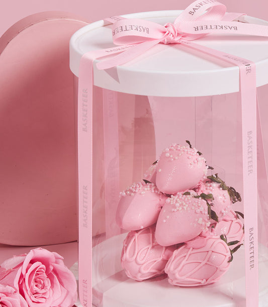 Charlotte Bakery: Pink chocolate-covered strawberries, some with pearl sprinkles or drizzle, presented in a gift dome with ribbon. Perfect artisan cake order for Bangkok delivery.