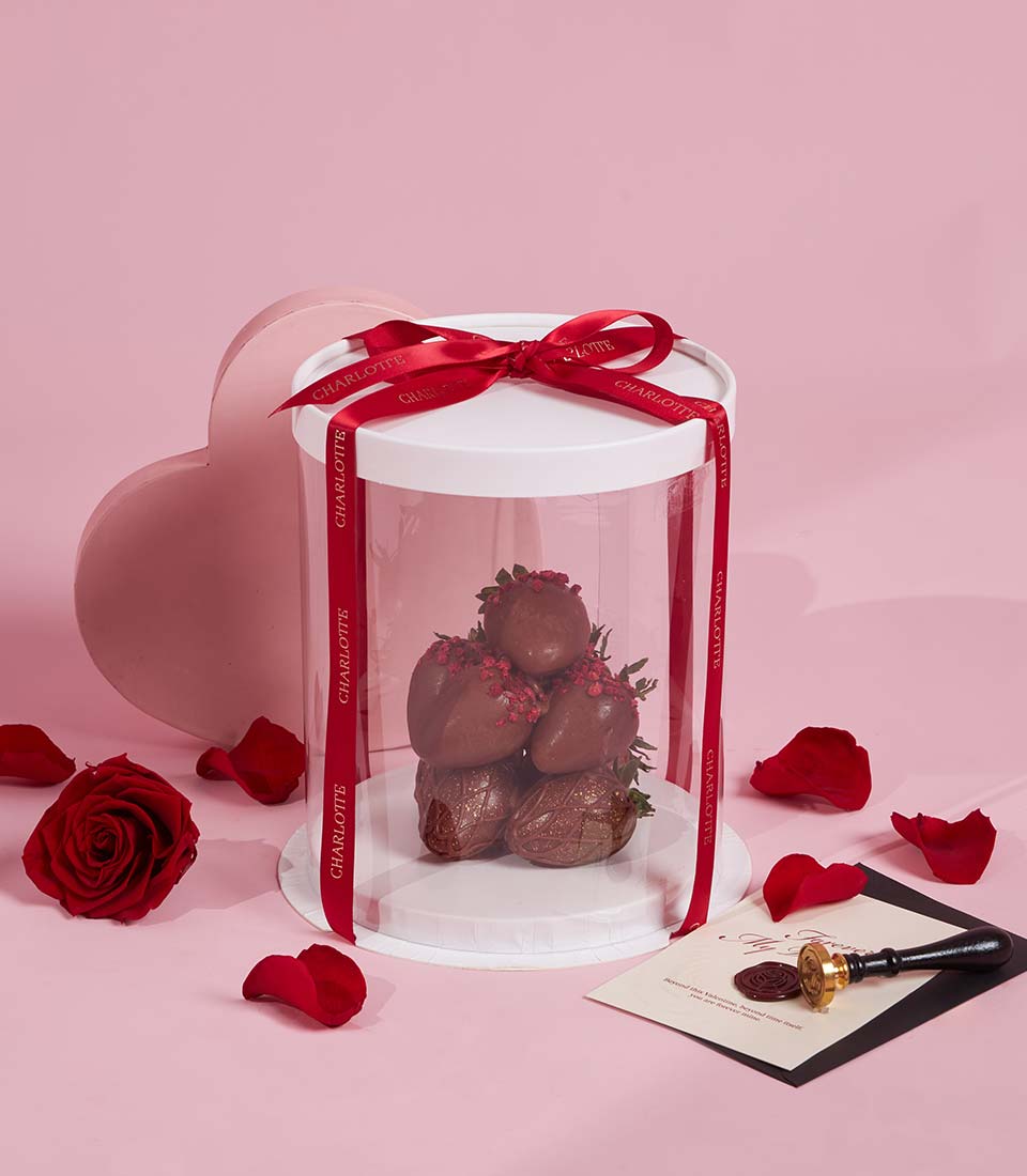 Dark chocolate-covered strawberries with raspberry sprinkles in red ribbon gift box for Valentine's Day