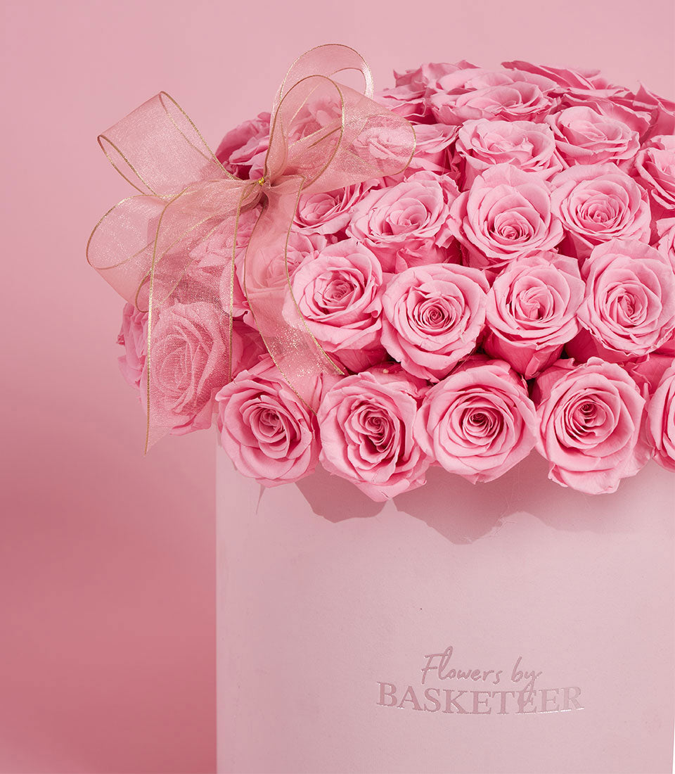 Lush arrangement of preserved pink roses from Flowers by Basketeer in a matching hat box with sheer ribbon. Premium flowers Bangkok delivery.