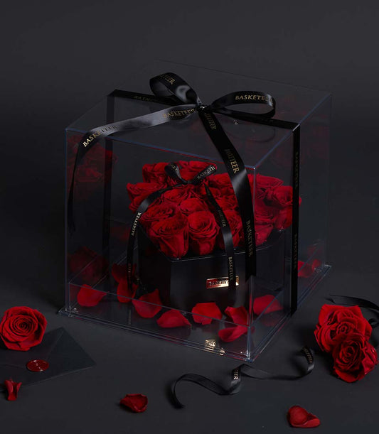 Luxury preserved red rose gift box with black satin ribbons and gold lettering for Valentine's Day