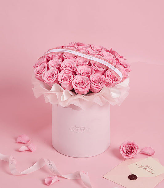 Sweet pink preserved rose arrangement in a round Flowers by Basketeer box. A luxurious, long-lasting gift for flower delivery in Bangkok, Thailand.
