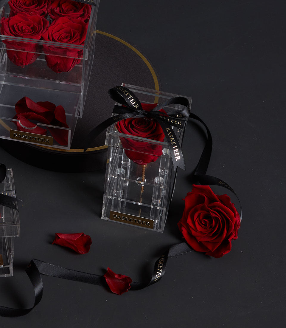 Eternal red rose in a tall acrylic VIP box from Flowers by Basketeer. A premium flower delivery in Bangkok, presented with a branded ribbon.
