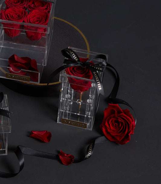 Eternal red rose in a tall acrylic VIP box from Flowers by Basketeer. A premium flower delivery in Bangkok, presented with a branded ribbon.