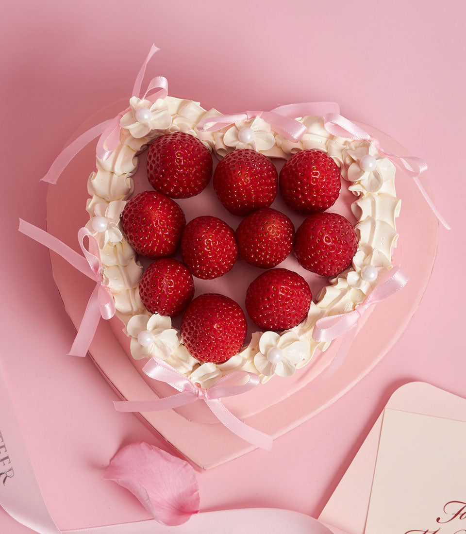Heart-shaped custom cake Bangkok from Charlotte Bakery. Fresh strawberries and pink cream topping, with delicate ribbon accents, perfect for birthday cake delivery.