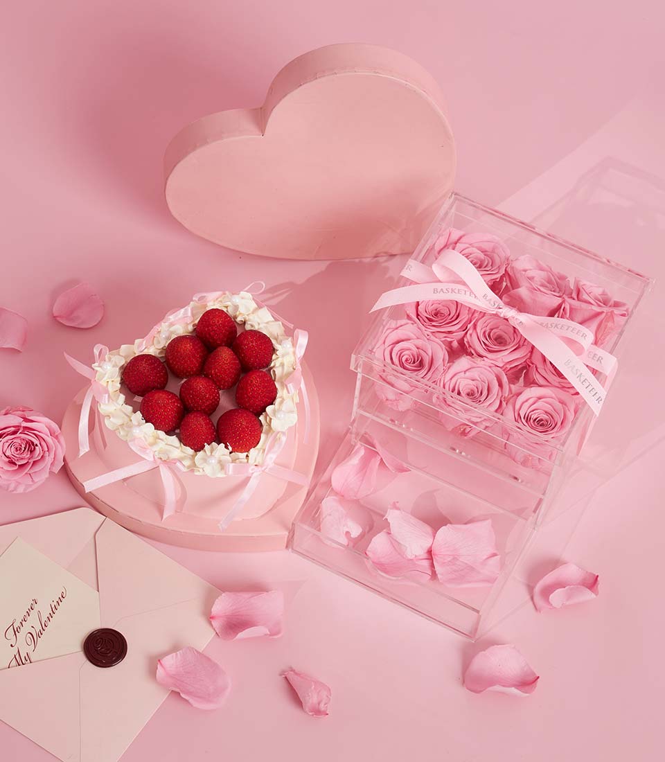 Charlotte Bakery heart-shaped artisan cake with fresh strawberries and cream. Paired with a box of delicate pink roses for birthday cake delivery Bangkok.