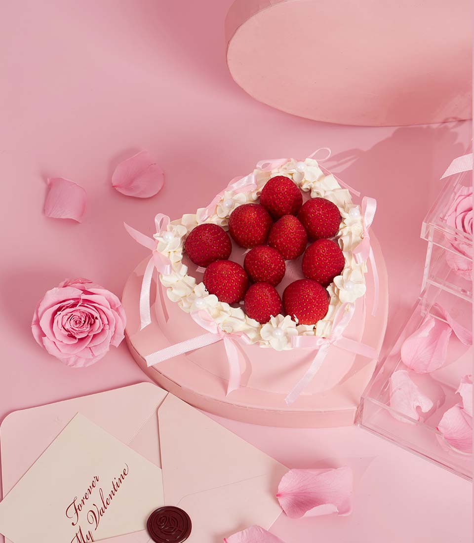 Charlotte Bakery artisan heart-shaped cake in a pink box, topped with fresh strawberries and whipped cream. Perfect for birthday cake delivery Bangkok.