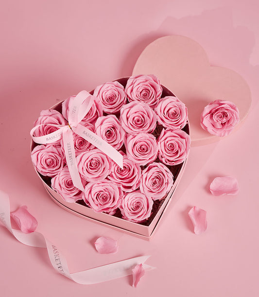 Elegant heart-shaped flower box from Flowers by Basketeer filled with delicate pink preserved roses and tied with a branded ribbon. Premium flowers Bangkok.