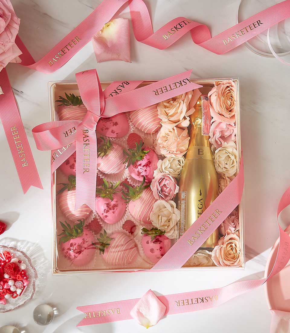 Luxury Valentine gift box with chocolate-dipped strawberries, champagne, and pink roses