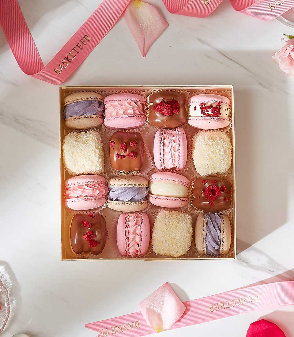Assorted macarons and chocolate pastries in luxury gift box with pink ribbon, birthday or celebration gifting