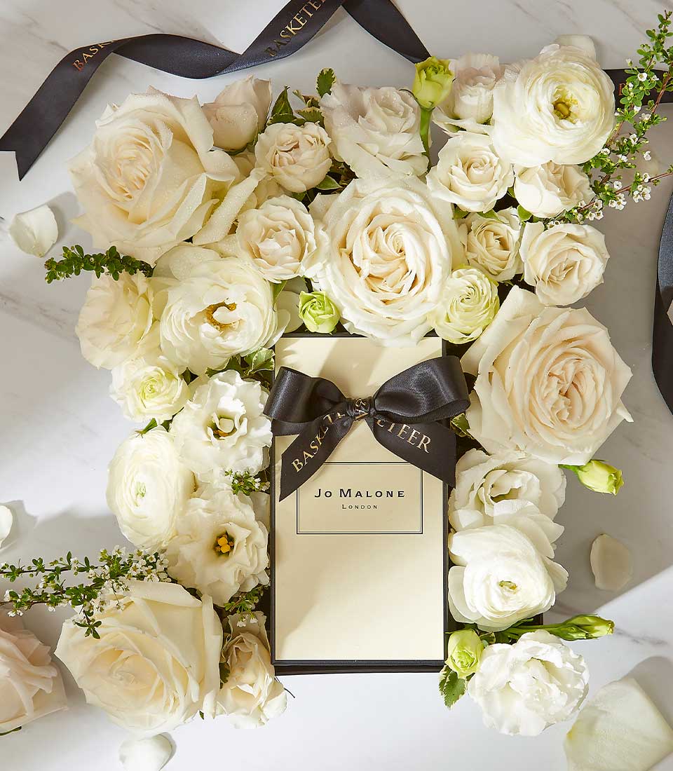 Luxury Jo Malone English Pear perfume gift box with cream roses and ranunculus arrangement