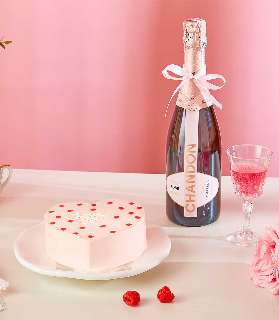 Rosé sparkling wine with heart-shaped pink cake and fresh raspberries, Valentine gift set