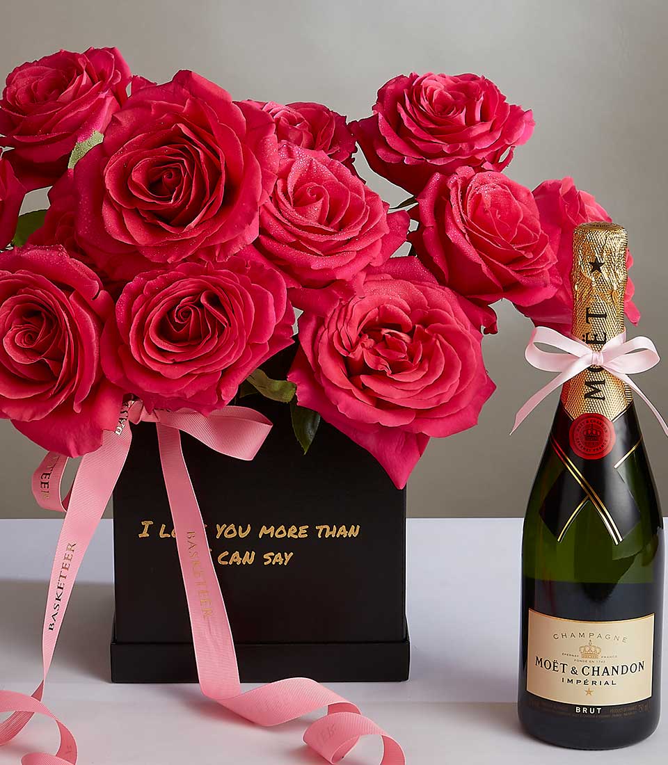 Pink roses with champagne luxury gift set for anniversary celebrations, featuring vibrant fuchsia blooms in black box with