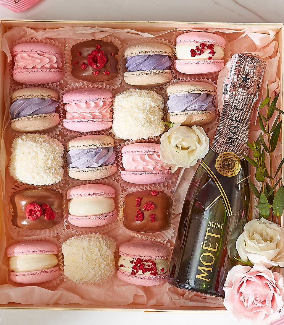 Luxury gift box with assorted macarons, champagne, and pink roses for Valentine's Day