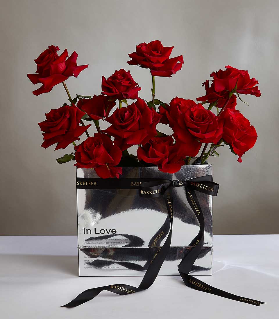 Vibrant red roses in silver luxury gift box with black ribbon, premium Valentine's anniversary flowers