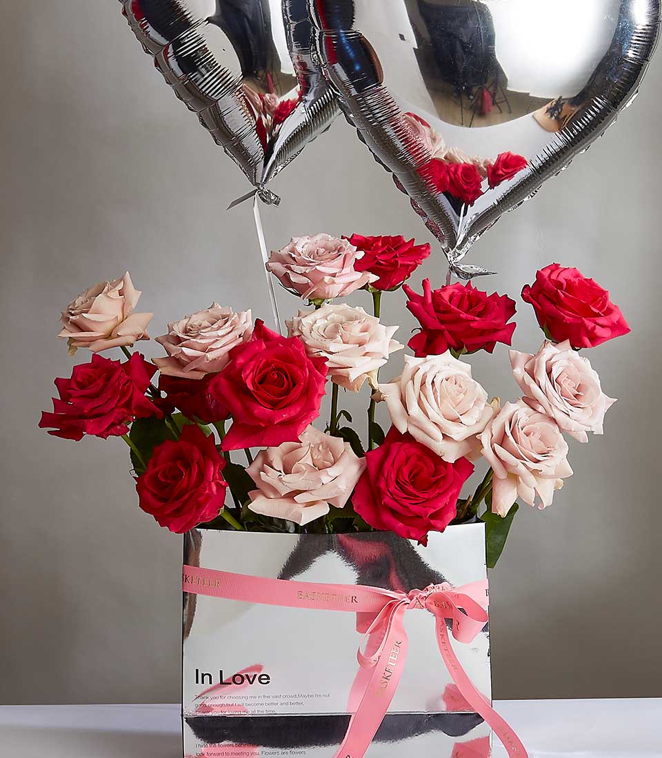 Fresh red and pink roses in silver box with heart balloons, Valentine's Day gift for her