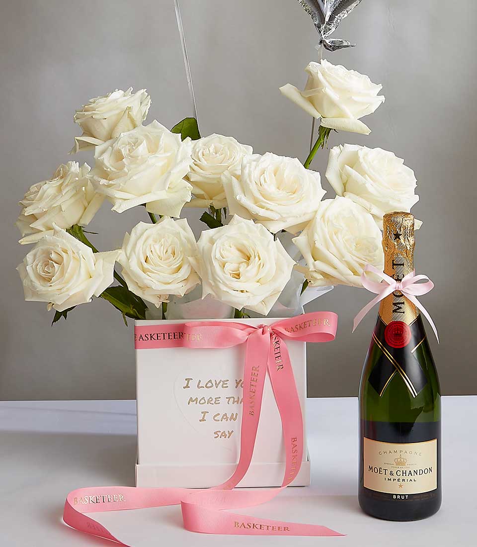 White roses and Moët & Chandon champagne anniversary gift set with gold-trimmed box and pink ribbon