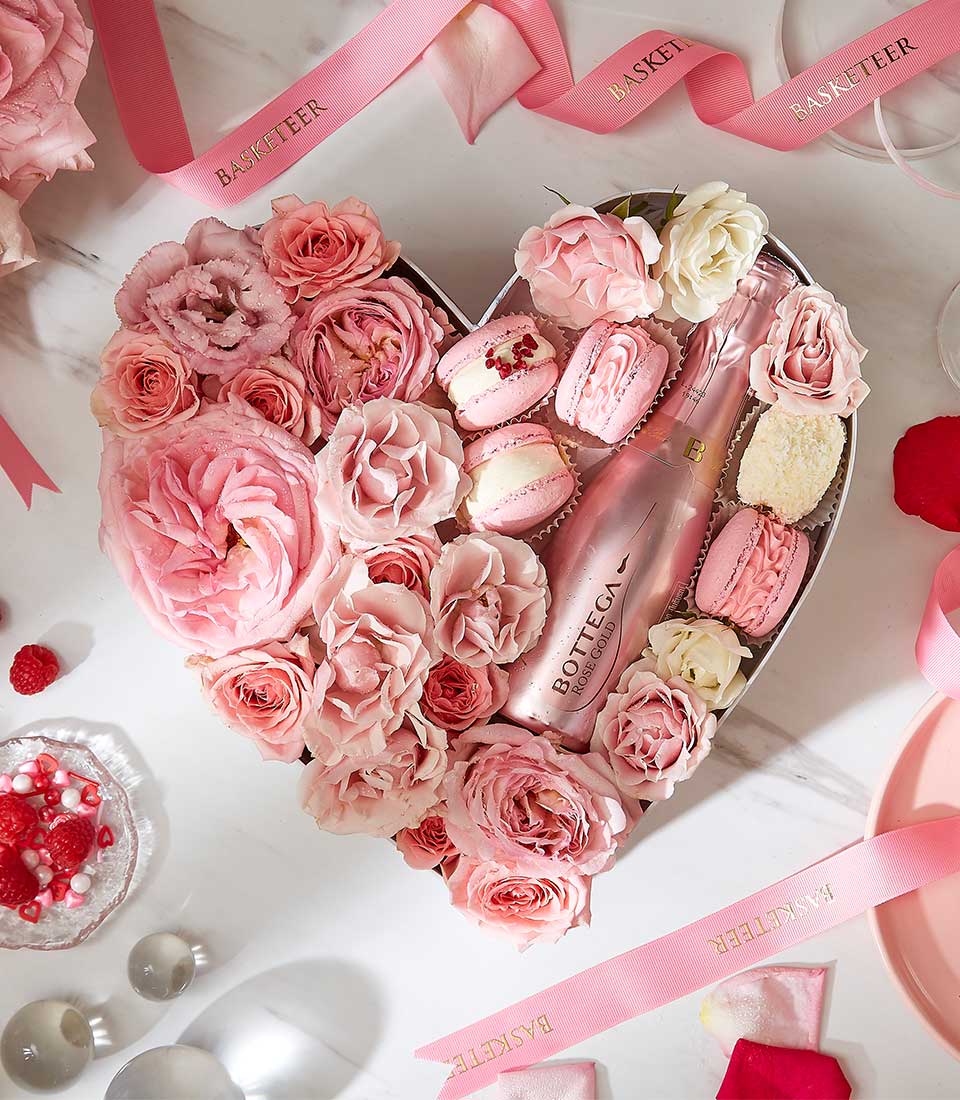 Heart-shaped luxury gift box with pink roses, macarons, and Bottega rosé sparkling wine for Valentine's Day