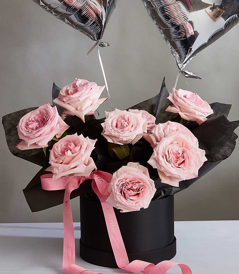 Pink O'Hara roses in black hatbox with heart balloons for Valentine's Day