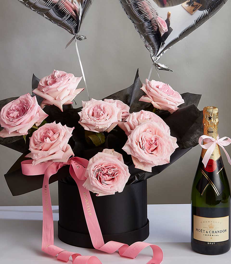 Elegant flower box from Flowers by Basketeer features blush pink roses, black tissue, pink ribbon, champagne, and balloons. Premium flowers Bangkok for a special gift.