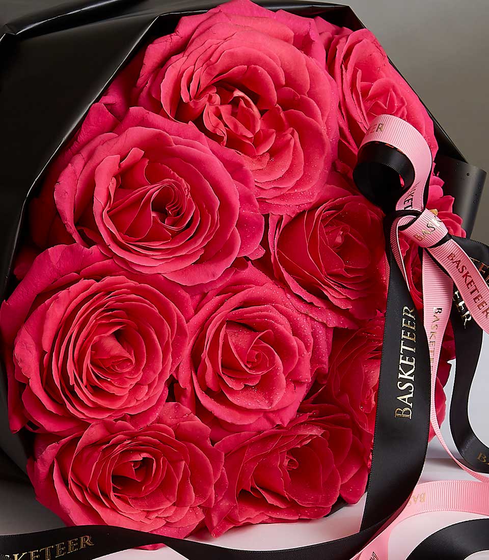 Deep pink roses bouquet with black wrapping and gold ribbon, fresh anniversary gift
