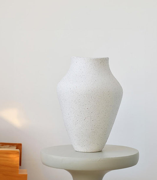 Speckled white ceramic vase with organic tapered shape and narrow opening