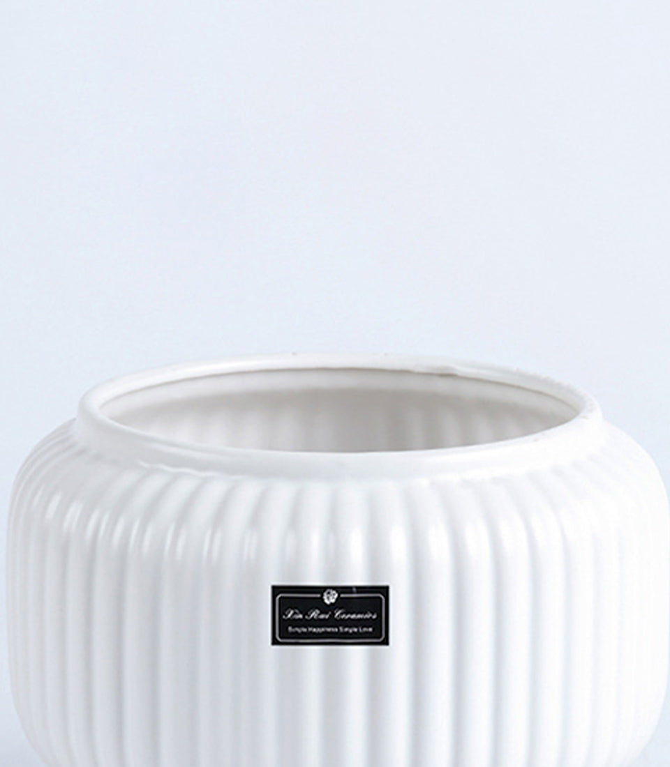 White ceramic fluted vase with ribbed texture, ideal for fresh flowers or decorative display