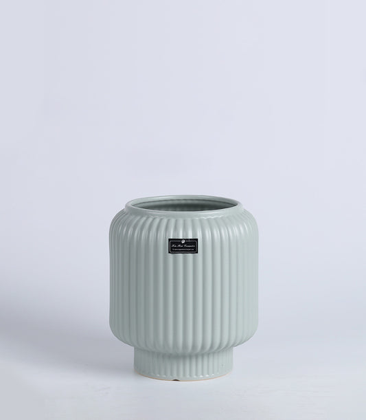 Sage green ceramic vase with ribbed texture and tapered cylindrical form