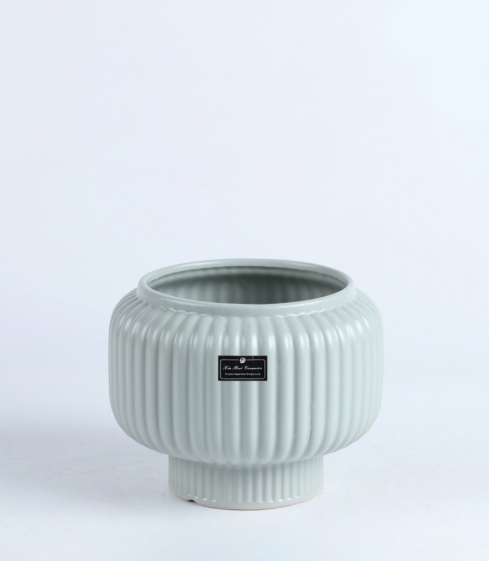 Light green ribbed ceramic vase with tapered cylindrical base
