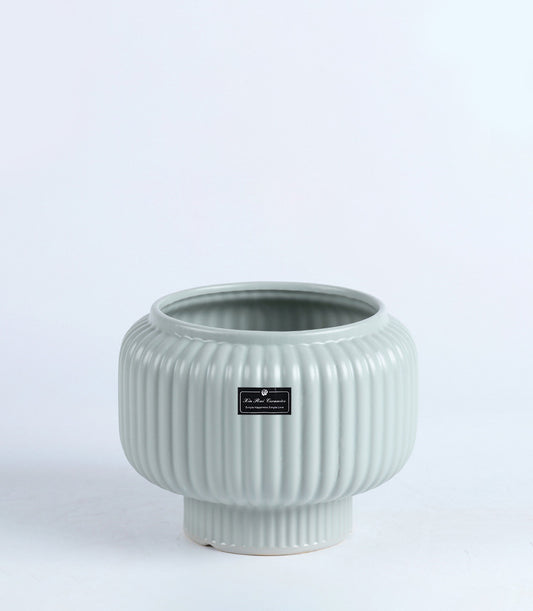 Light green ribbed ceramic vase with tapered cylindrical base