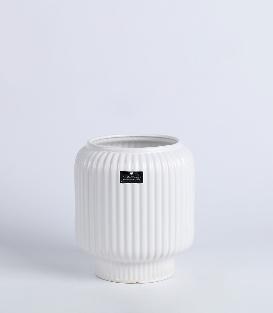 White ribbed ceramic vase with textured cylindrical body and flared base