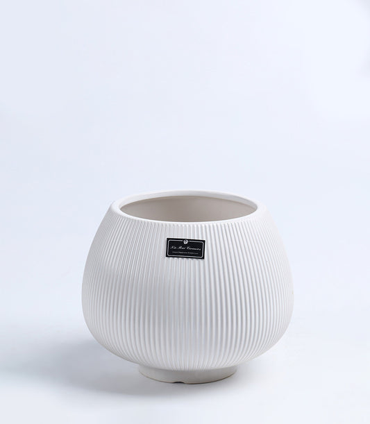 White ribbed ceramic vase with fluted texture and integrated base, ideal for fresh flowers or minimalist home décor