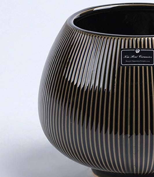 Black ceramic vase with metallic gold ribbed stripes and tapered rounded body for elegant home styling